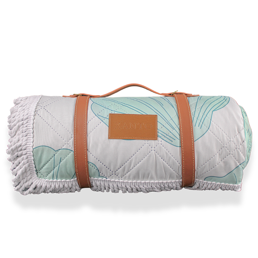 Luxury beach picnic setup featuring an elegant beach blanket and stylish picnic blanket for a perfect seaside retreat