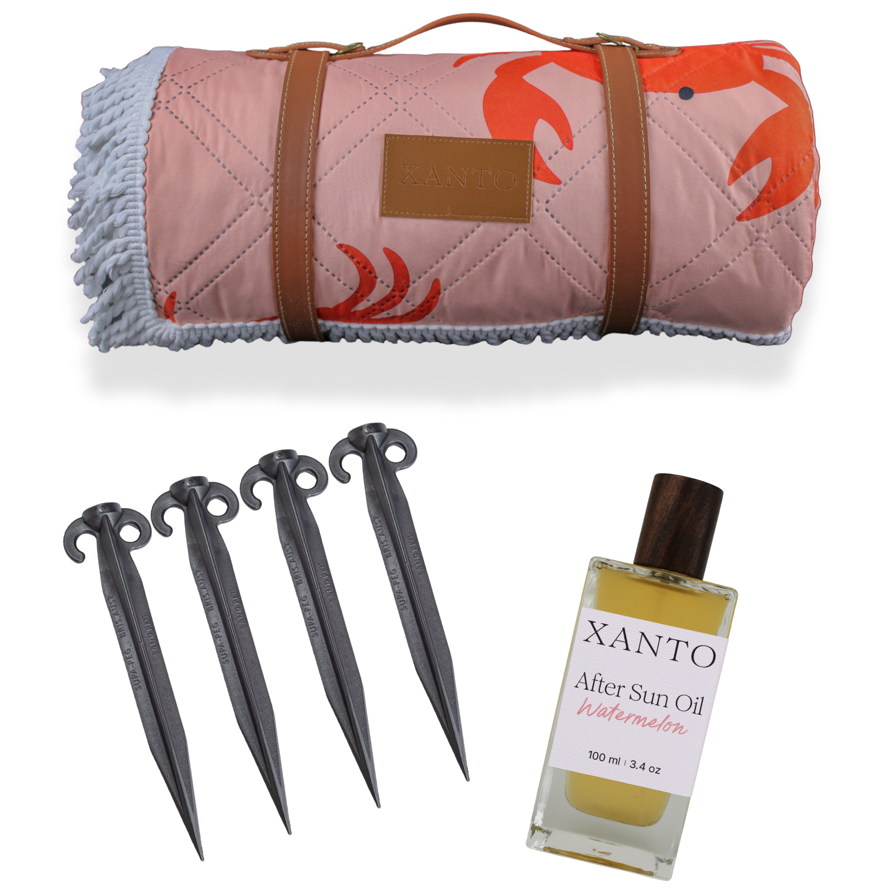 Beach scene with after-sun oil, colorful beach blanket, picnic blanket secured by sand pegs for a perfect seaside day