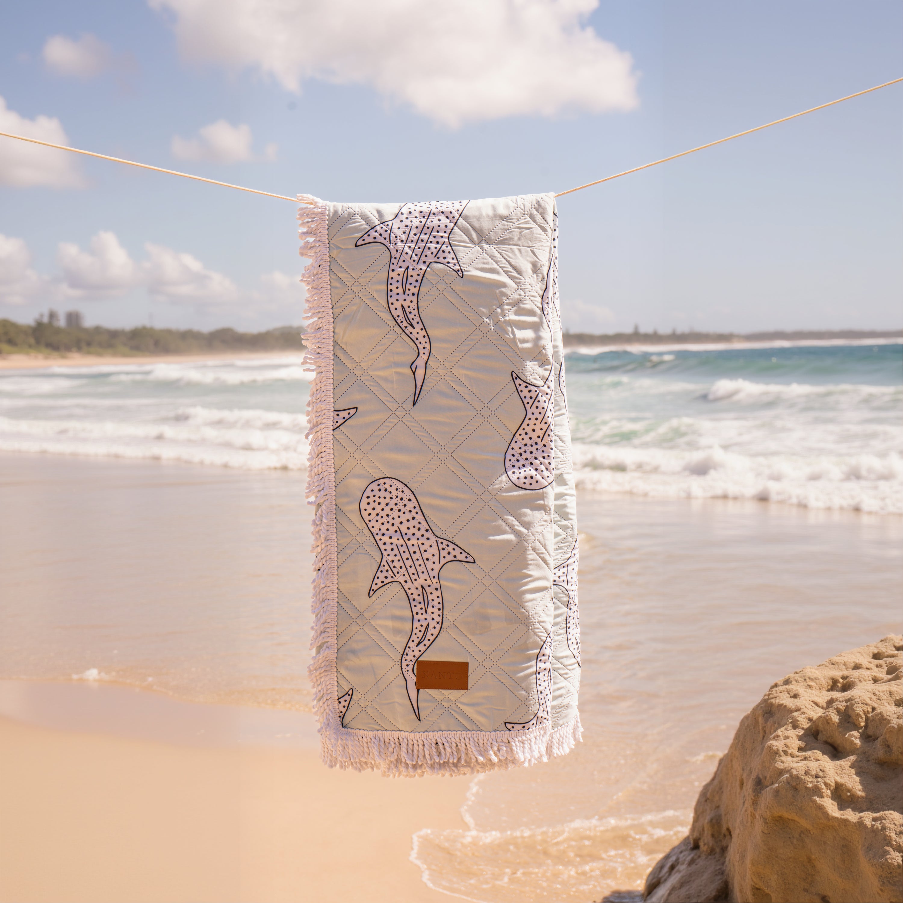 Beach picnic setting with a cozy beach blanket and durable picnic blanket for outdoor relaxation