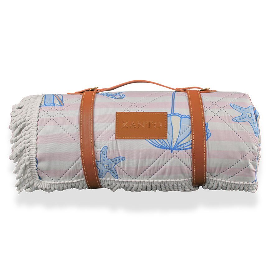 Enjoy a sunny day at the beach with a cozy picnic blanket for the perfect outdoor picnic experience